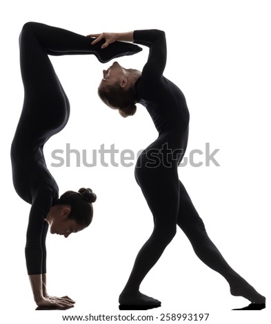 two women contortionist practicing gymnastic yoga in silhouette on white background