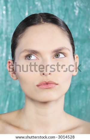 studio shot beauty portrait of a beautiful green eyes looking up young and expressive women on a electric blue background