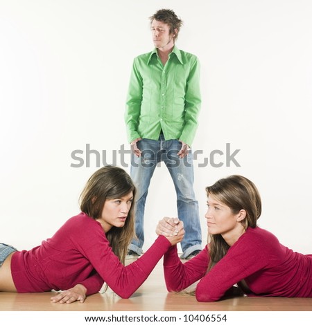 studio shot pictures on isolated background of two sisters twin women friends women fighting in arm wrestling for a man