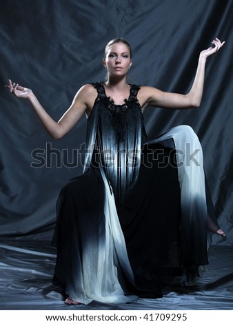 fashion pictures of a beautiful woman wearing silk fringe black and white dress chinese style doing martial arts posture