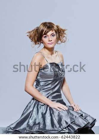 beautiful young caucasian woman girl evening dress sitting full length on the floor on studio isolated plain background