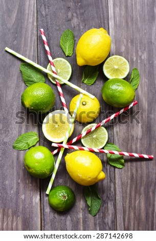 Fresh lime and juicy citrus with cocktail sticks on wooden table