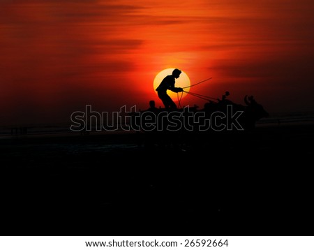 A beautiful background of a silhouetted man standing on a cart, on the backdrop of the setting sun on an Indian beach. Space for text below.
