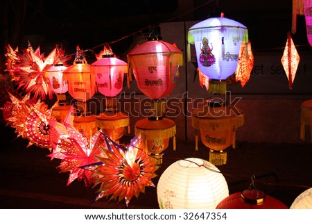 Colorful lanterns with \'Happy Diwali\' captions and pictures of gods and goddesses, beautiful lit on the occasion of Diwali festival in India.