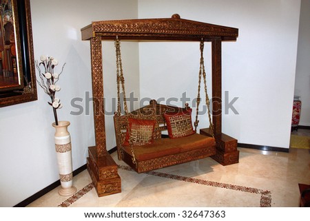A traditionally carved ethnic wooden swing in a royal Indian house.