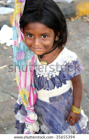 A shy Indian beggar girl looking at the camera.
