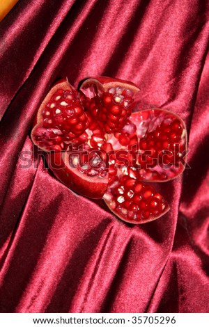 A freshly cut pomegranate fruit displayed on a satin, in a fruit shop.