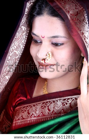 A beautiful Indian woman wearing a green sari covering her head traditionally, on the occasion of a festival.
