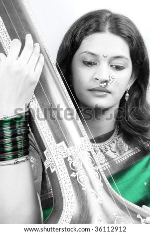 A classic portrait of a classic Indian music singer with a intrument called tanpura.
