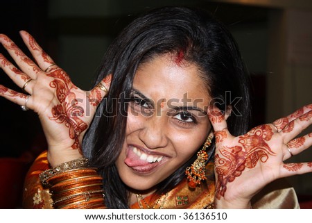 A portrait of an Indian lady wearing the traditional henna and bangles, in a teasing mood.