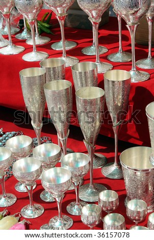 A view of antique silver utensils with beautiful carvings for sale in an Indian antique shop.