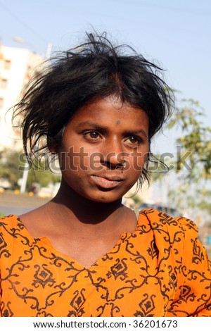 A portrait of a poor Indian girl wearing a yellow dress.