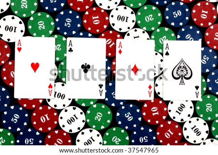 A poker hand of \'Four of a Kind\' consisting of 4 aces in this case, on colorful gambling chips.
