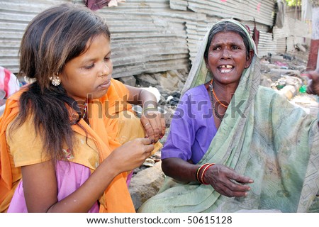 A streetside teenage girl is worried as her jobless grandmother is crying being jobless, in India.