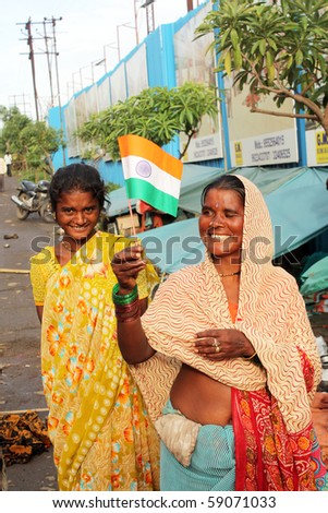PUNE, MAHARASHTRA/INDIA August 15: A poor street side lady holding the Indian flag on the 64th Indian independence day on August 15, 2010 in Pune, Maharashtra, India.