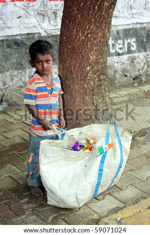 PUNE, MAHARASHTRA/INDIA August 15: A poor Indian boy stands with a huge bag containing Indian flags to be sold on the 64th Independence day on August 15, 2010 in Pune, Maharashtra, India.