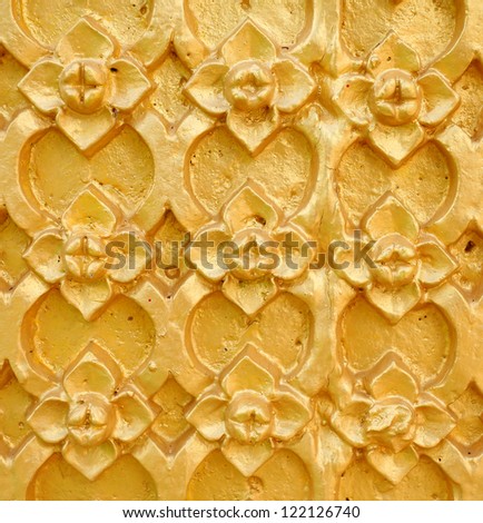 gold patterned thai art on wall in temple