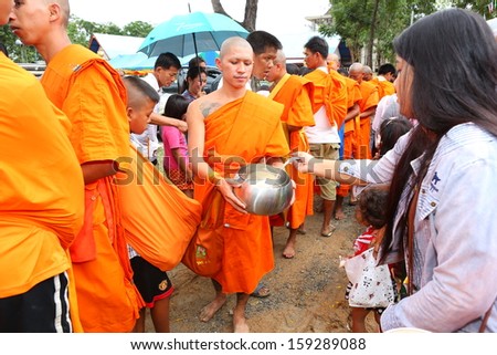 NAKHONSAWAN, THAILAND - OCT 20 : Unidentified Buddhist monks are given food offering from people in the morning for End of Buddhist Lent Day. on October 20, 2013 in Nakhonsawan, Thailand.