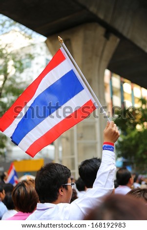 BANGKOK,THAILAND - DECEMBER 20: Employees at Silom neighborhood holds flag for anti-government. The protest Against The Amnesty bill in Bangkok, capital of Thailand on 20 December 2013