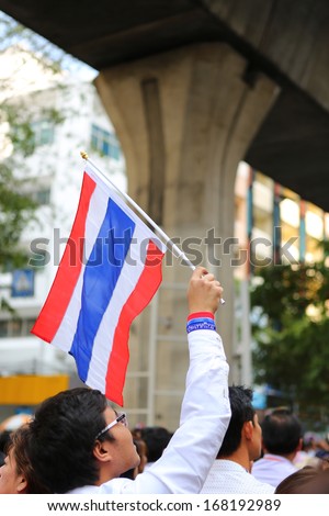 BANGKOK,THAILAND - DECEMBER 20: Employees at Silom neighborhood  holds flag for anti-government. The protest Against The Amnesty bill in Bangkok, capital of Thailand on 20 December 2013