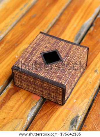 Tissue box of rattan basketry on wooden table
