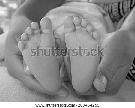 baby foot in hand mom, black and white