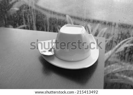 coffee mug on a table, black and white