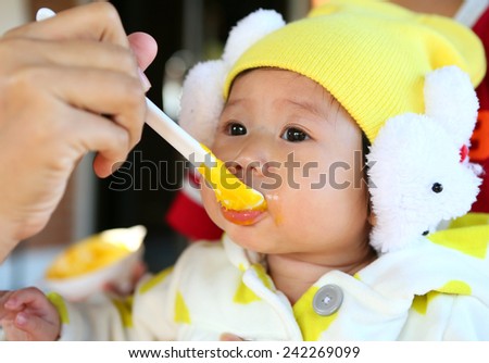 Close up Five month old South East Asian Thai baby girl being spoon fed