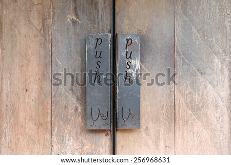 Closed wooden door with signs instructing to Push