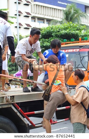 BANGKOK, THAILAND - OCTOBER 29 : Volunteers help residents into a big truck to escape rising flood waters at Pinklao Bridge, in Bangkok, Thailand on Oct. 29, 2011.