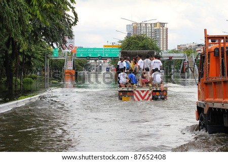BANGKOK, THAILAND - OCTOBER 29 : Unidentified people sit and stand in big truck to escape rising flood waters at Pinklao Bridge, in Bangkok, Thailand on Oct. 29, 2011.