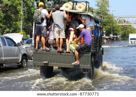 BANGKOK THAILAND - OCTOBER 30 : Unidentified people sit and stand in big truck to escape rising flood waters at Vipavadeerangsit Road Donmuang domestic airport, in Bangkok, Thailand on Oct. 30, 2011.