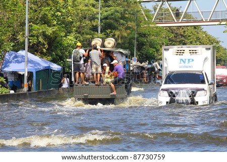 BANGKOK THAILAND - OCTOBER 30 : Unidentified people sit and stand in big truck to escape rising flood waters at Vipavadeerangsit Road Donmuang domestic airport, in Bangkok, Thailand on Oct. 30, 2011.