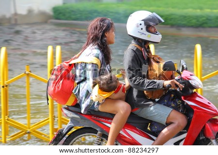 BANGKOK THAILAND - NOVEMBER 5 :  unidentified people on motorcycle, Heavy flooding from monsoon rain from north Thailand arriving in ladprao Road on November 5, 2011 in Central Bangkok, Thailand.