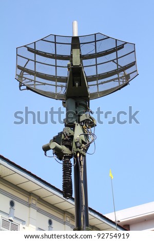 Military radar dish against blue sky