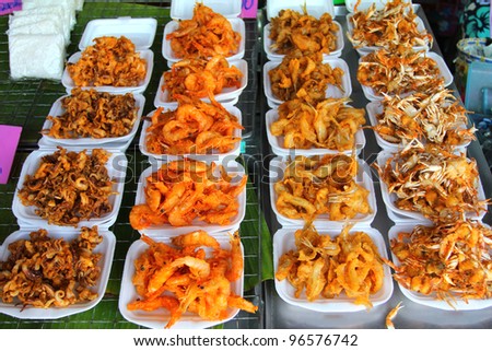 assortment of fried seafood on the table (squid, shrimp, fish and crab)