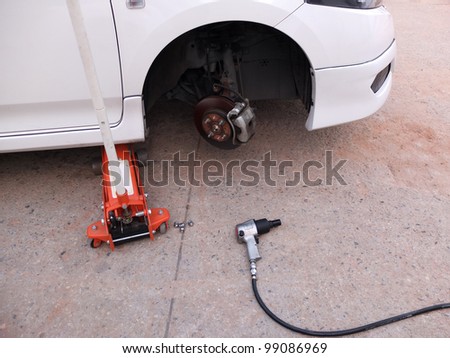 Car without tire at jack in service