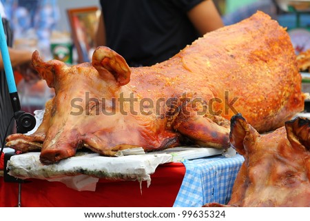 Golden whole roasted pig. Spit roasting is a traditional international luau method of cooking a whole pig.