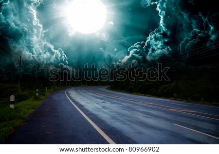asphalt road and dark thunder clouds over it