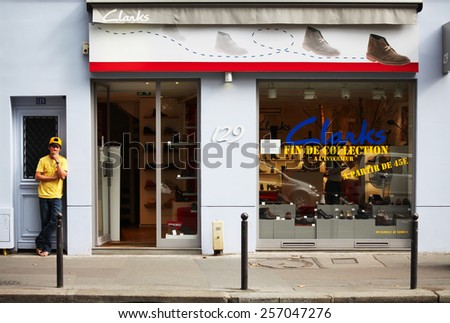 PARIS, FRANCE - AUGUST 31, 2012: Young man is waiting next to a Clarks store in Paris, France. He`s waring clothes in the same color as the text on the store.