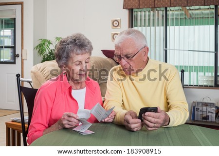 An elderly couple try to figure out how to use their new phone.