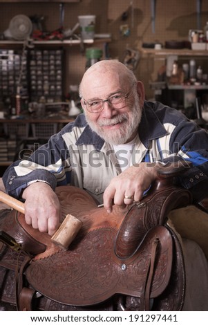 Portrait of a smiling, happy leather craftsman in his eighties.