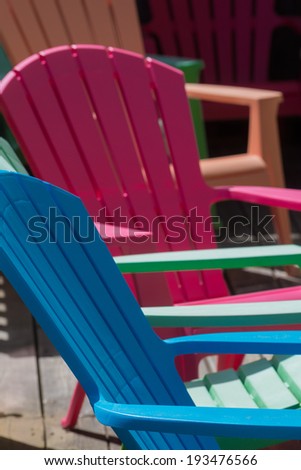 Colorful plastic deck chairs on an outdoor patio.