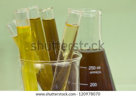 yellow to brown liquid fluid filled test tubes on a green background
