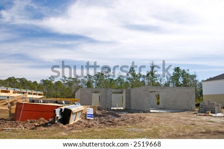 new concrete home construction with stacks of building materials