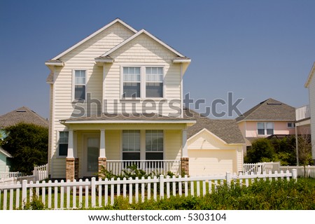 simple Florida cottage style home with white picket fence near the beach
