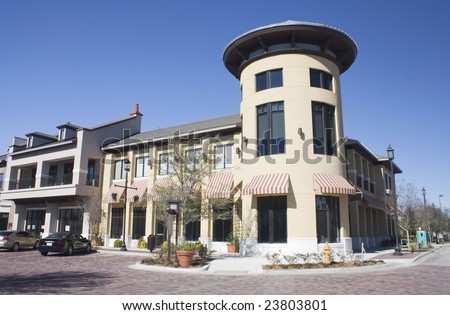 commercial strip mall with circular corner tower and striped awnings