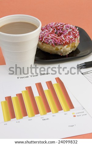 reviewing current sales figures with coffee and sprinkled donut