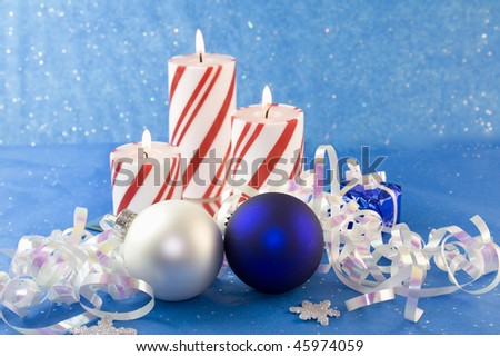 pearl white and blue ornaments with three red striped Christmas candles