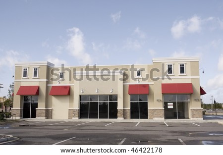 upscale pastel strip mall building with red awnings and tinted glass